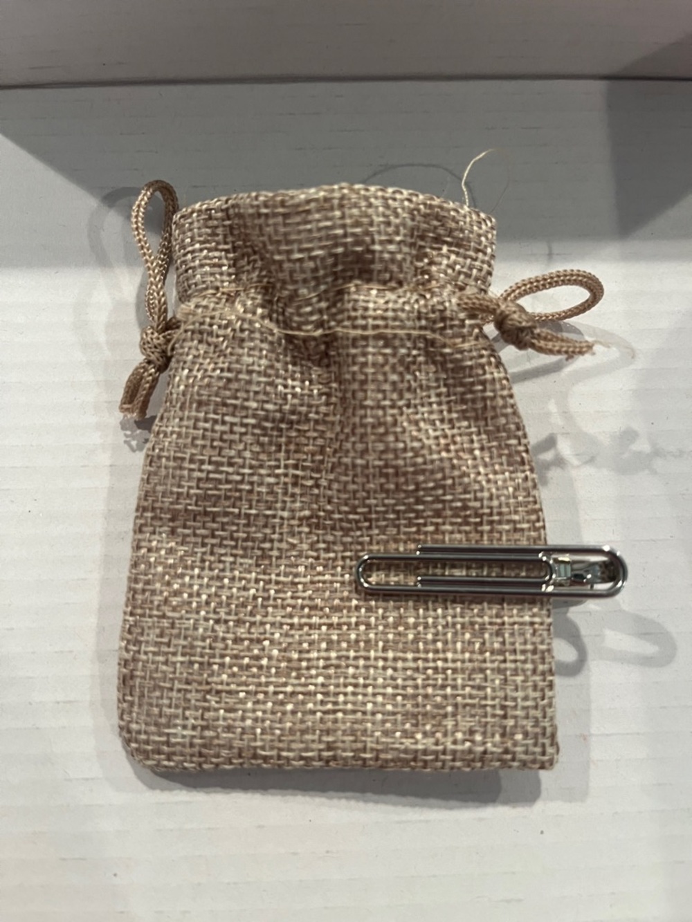 Lawrence Hunt silver tone paperclip tie clip with burlap drawstring pouch